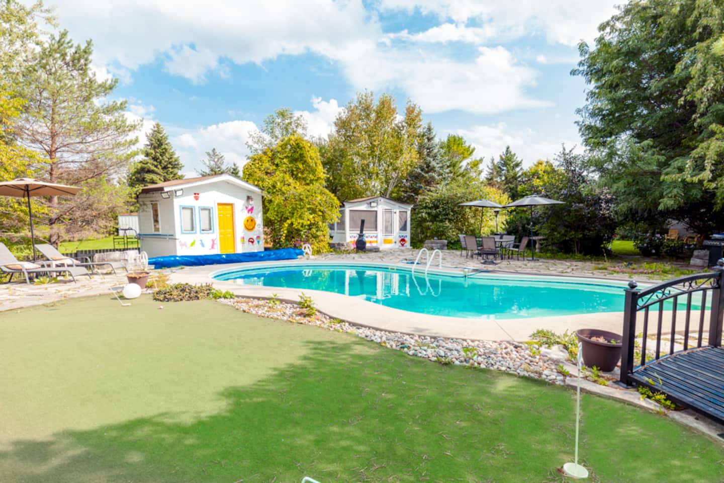 Heated in-ground pool, putting green and playhouse in the fenced backyard